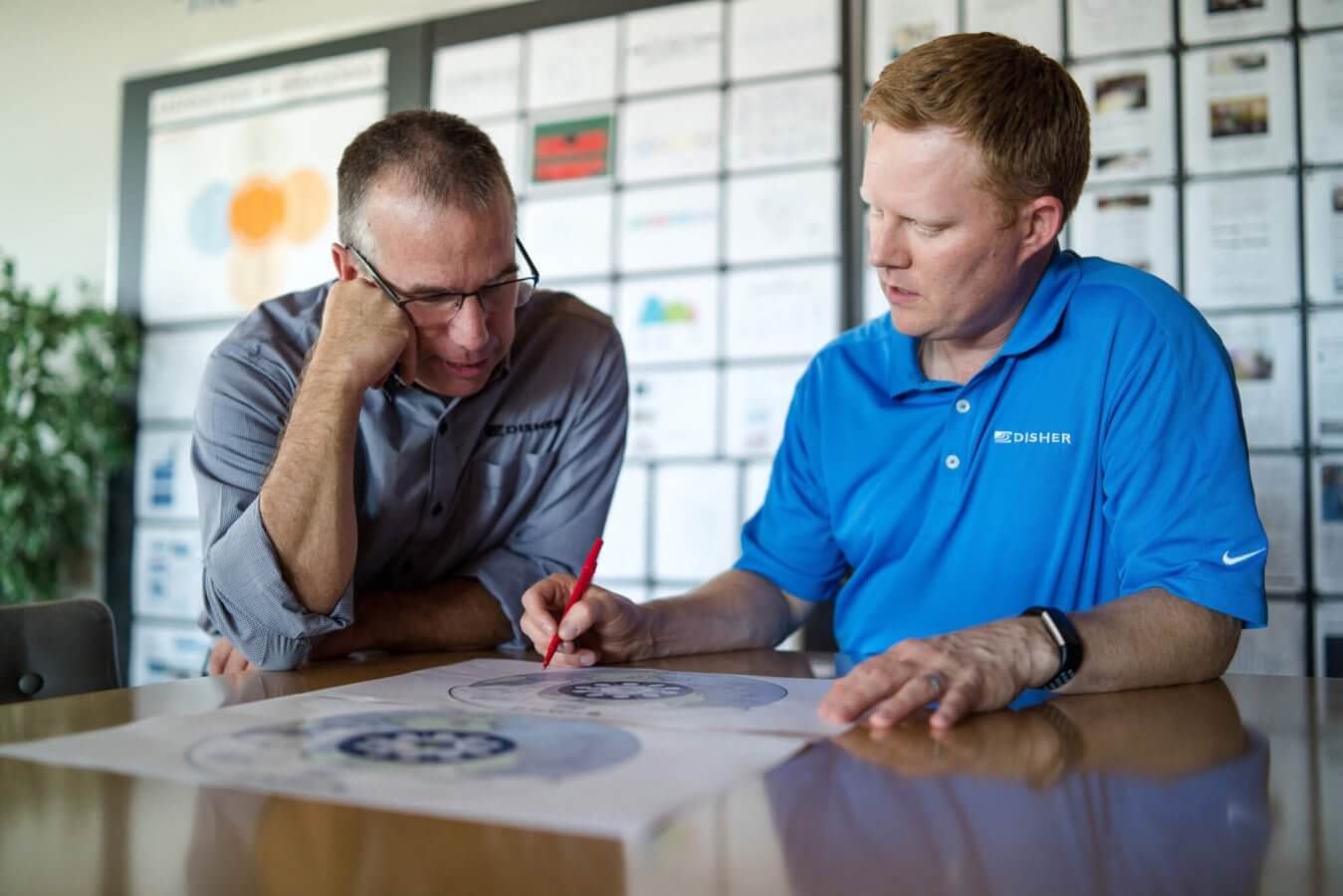 Two men look over a graphic