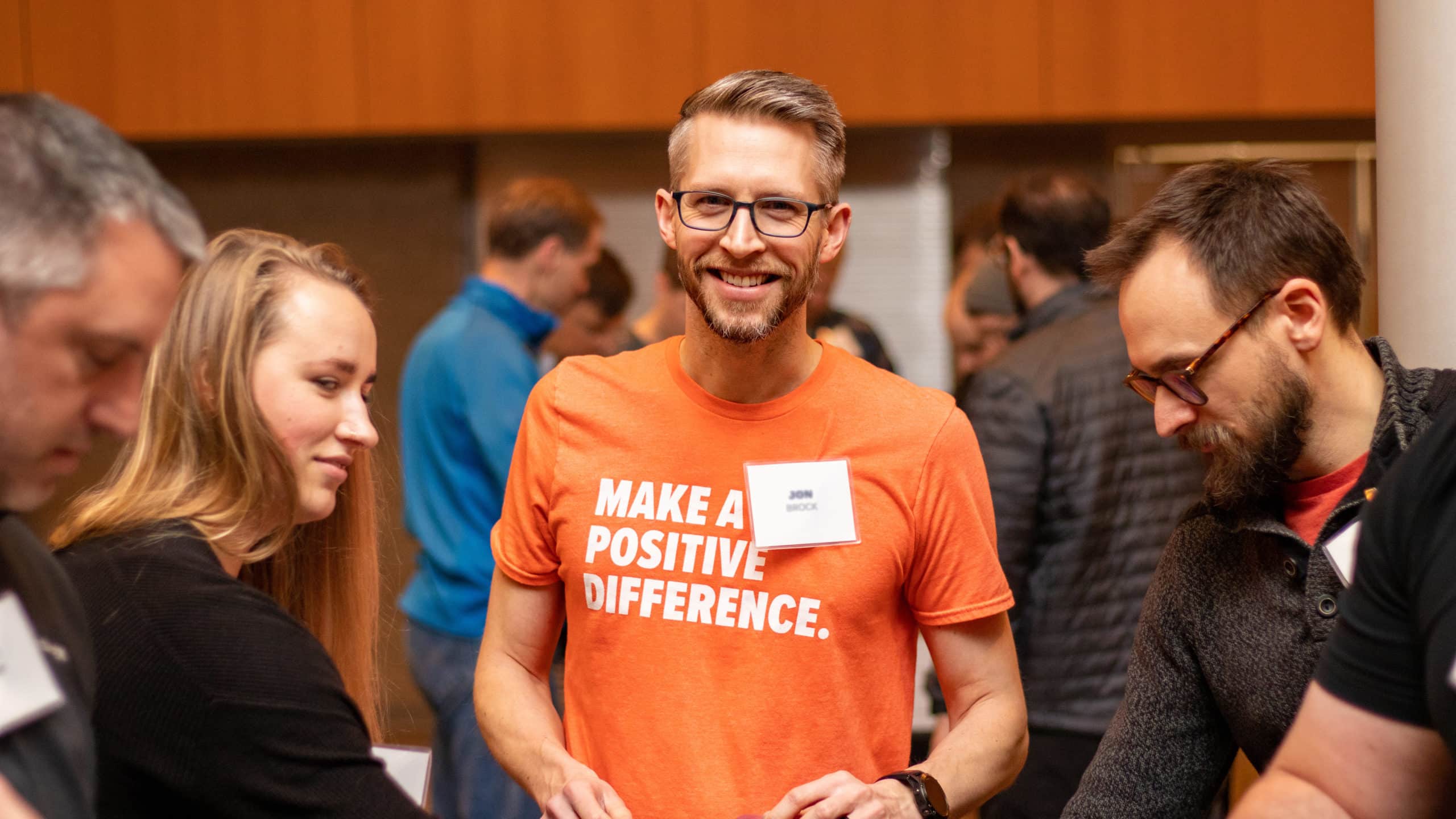 DISHER employee smiles as he packs hygiene bags for a stewardship projects