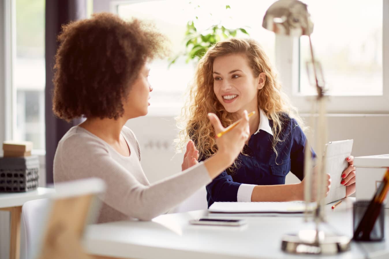 two women in the workplace chat together