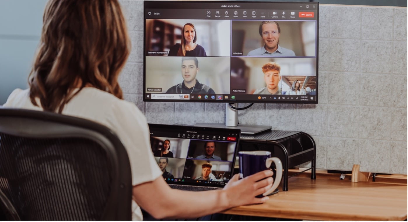 A women sits at her computer while on a remote conference call with other coworkers