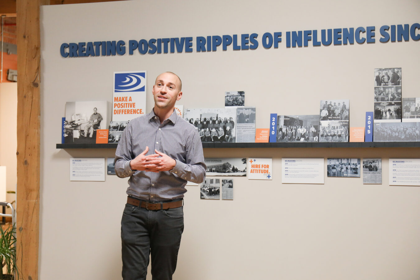 Joe Dyer standing in front of DISHER's mission wall